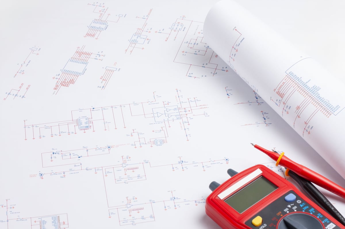 Diagrama unifilar y planos eléctricos sobre mesa de ingeniero