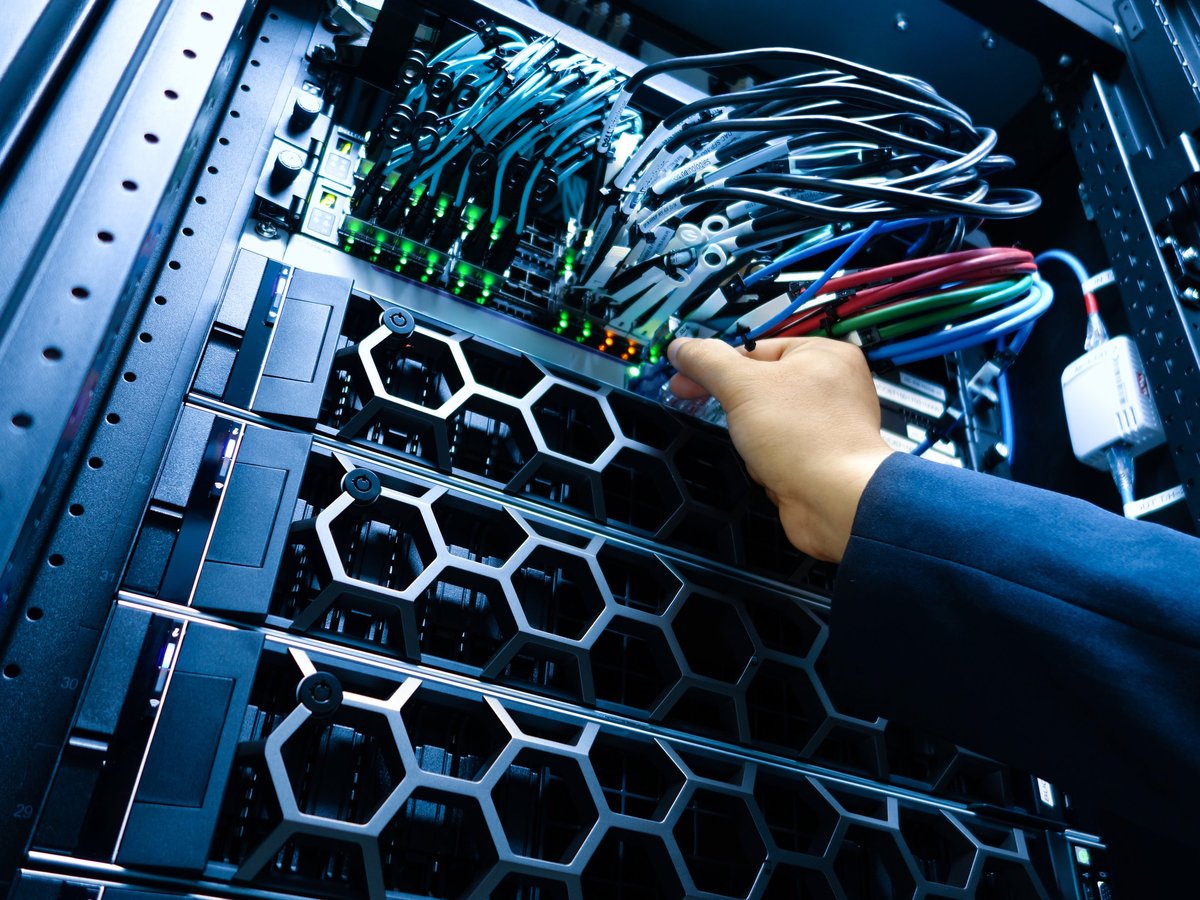 Técnico realizando mantenimiento en rack de servidores con cableado estructurado