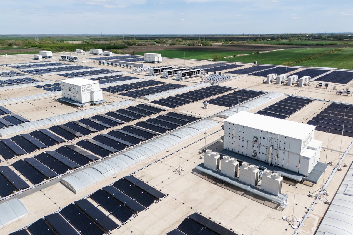 Aerial view of modern logistics building with solar panels and energy storage on roof