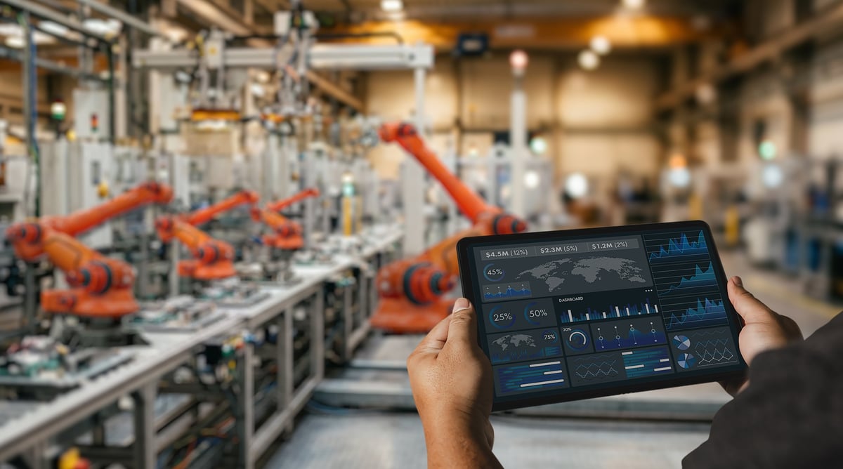 Ingeniero usando dashboard en fábrica inteligente con sistema robótico para monitoreo de producción industrial