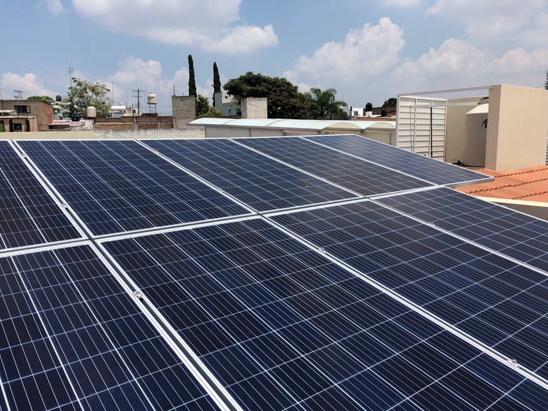 Solar panels installed on a rooftop with buildings and blue sky in the background