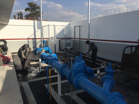 Blue industrial pump system with pipes mounted on a truck trailer at a water treatment facility