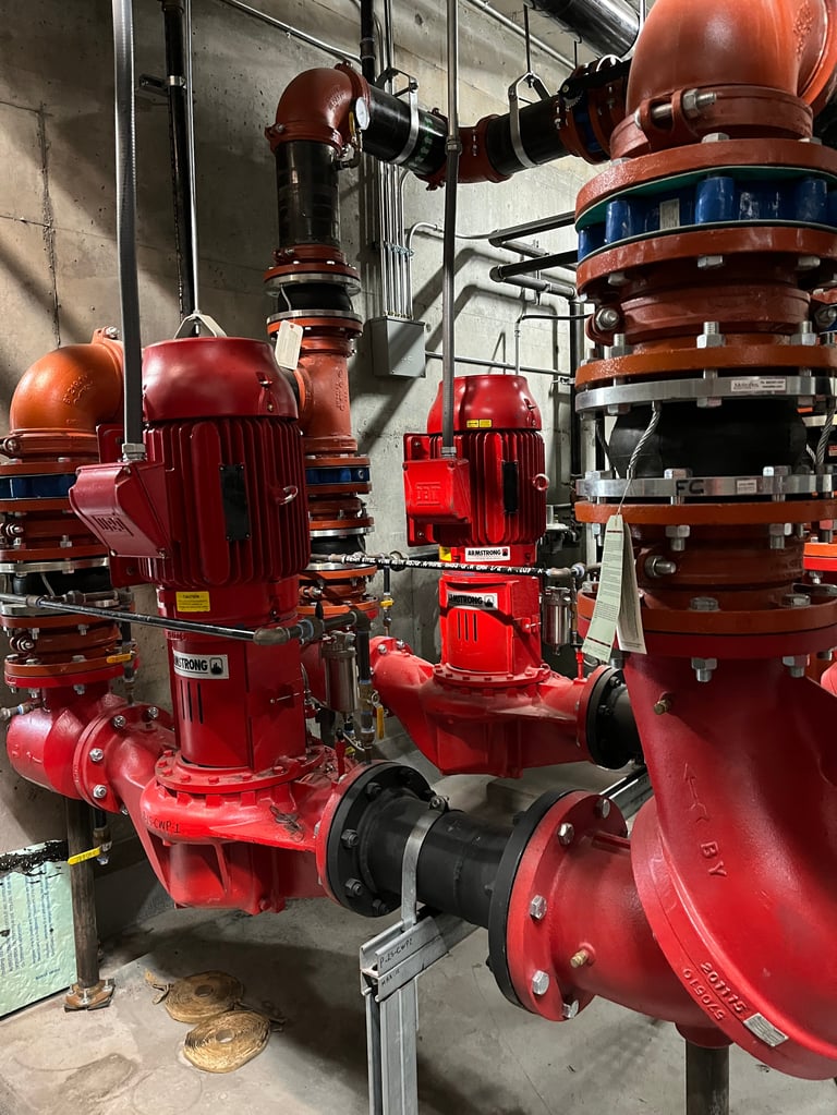 Industrial red fire pumps and motors mounted on metal framework in a facility