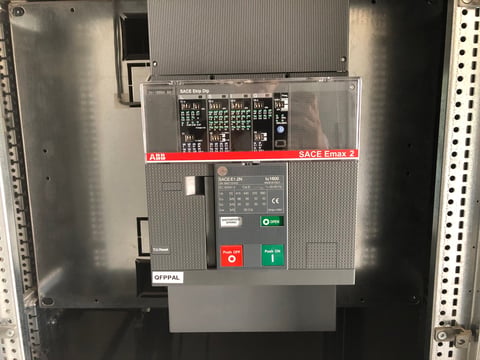 ABB electrical switchboard mounted in metal enclosure with red and green control buttons and terminal blocks